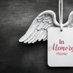a white tag with text in memory and angel wings